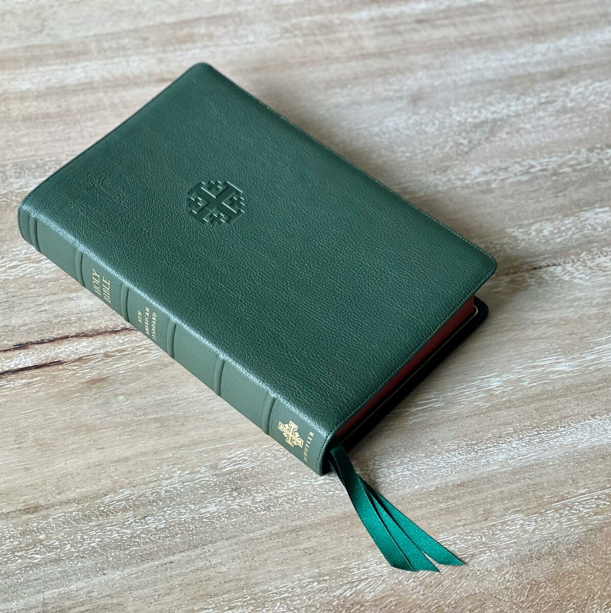a green book sitting on top of a wooden table